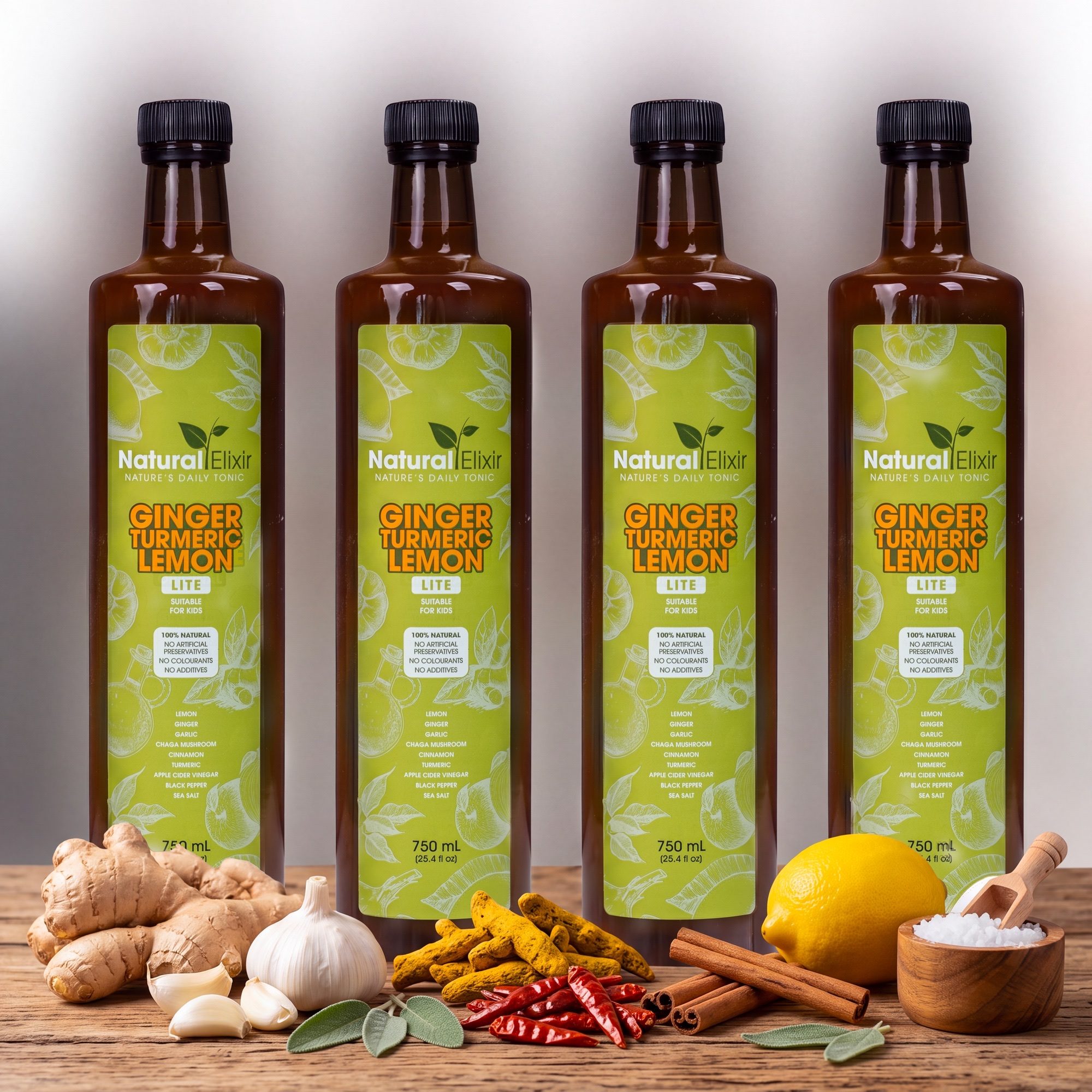 Four bottles of Natural Elixir LITE health tonic on a wooden counter with fresh ginger, garlic, turmeric, lemon, cinnamon and sea salt