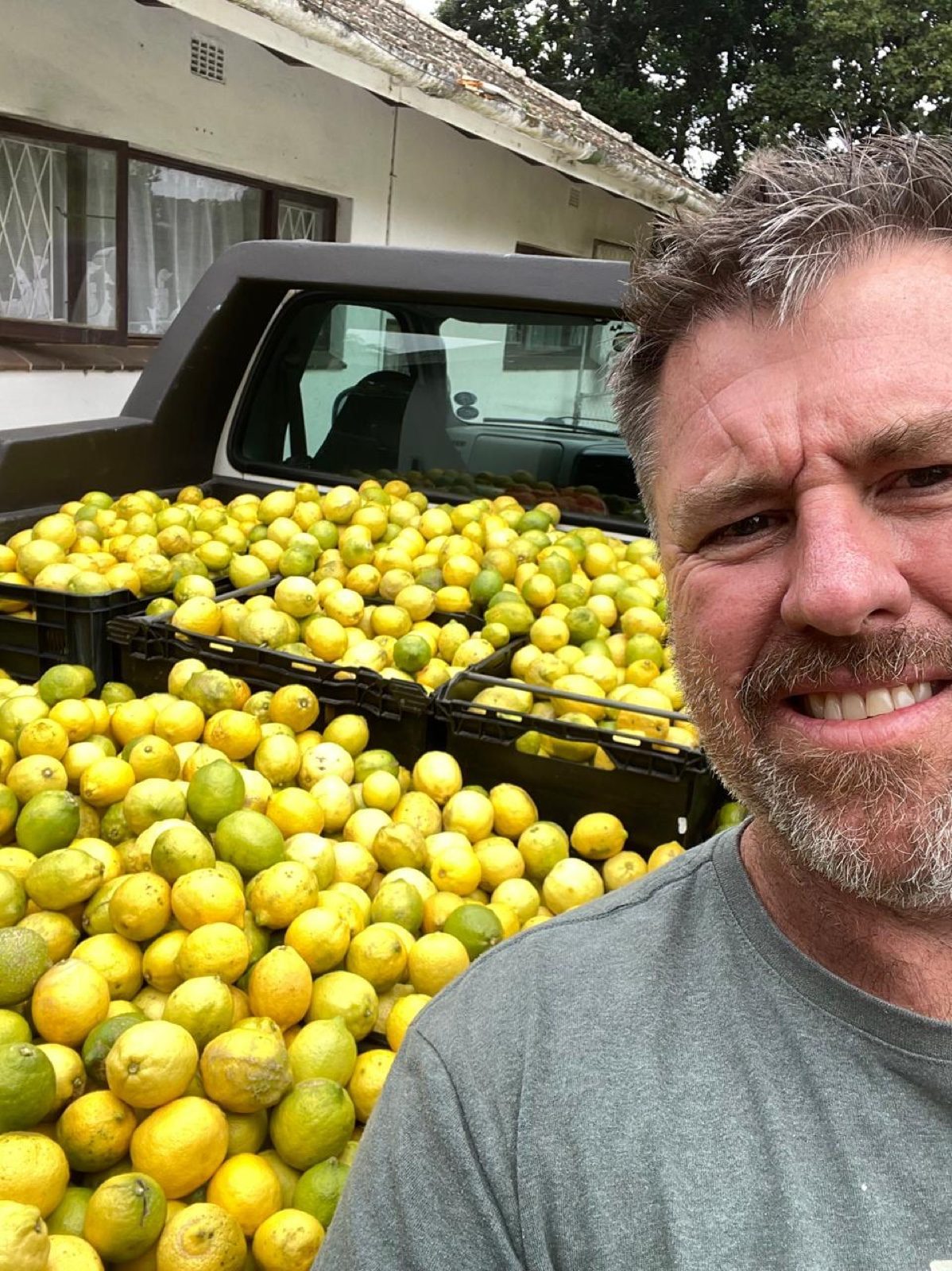 Brett Austin beside a bakkie loaded with crates of freshly picked lemons