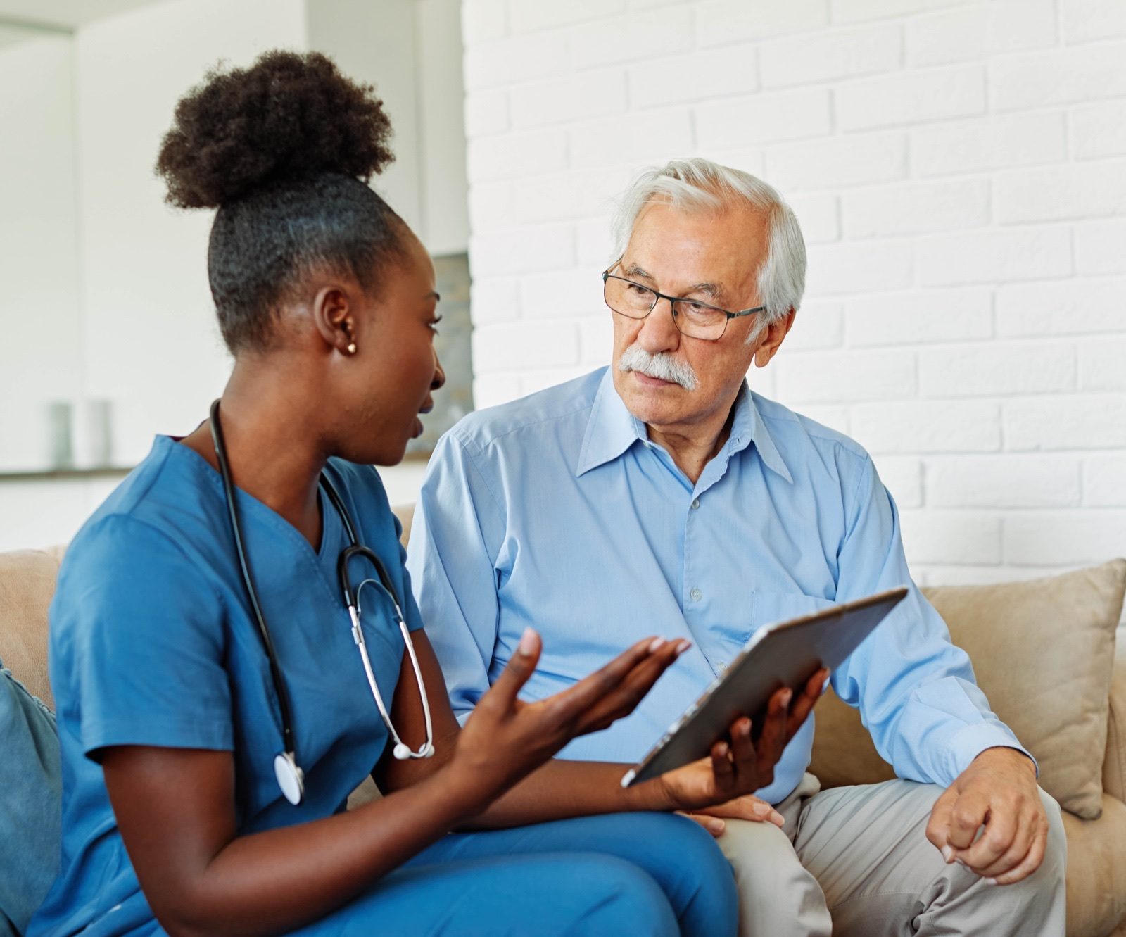 A healthcare professional explaining test results on a tablet to a patient