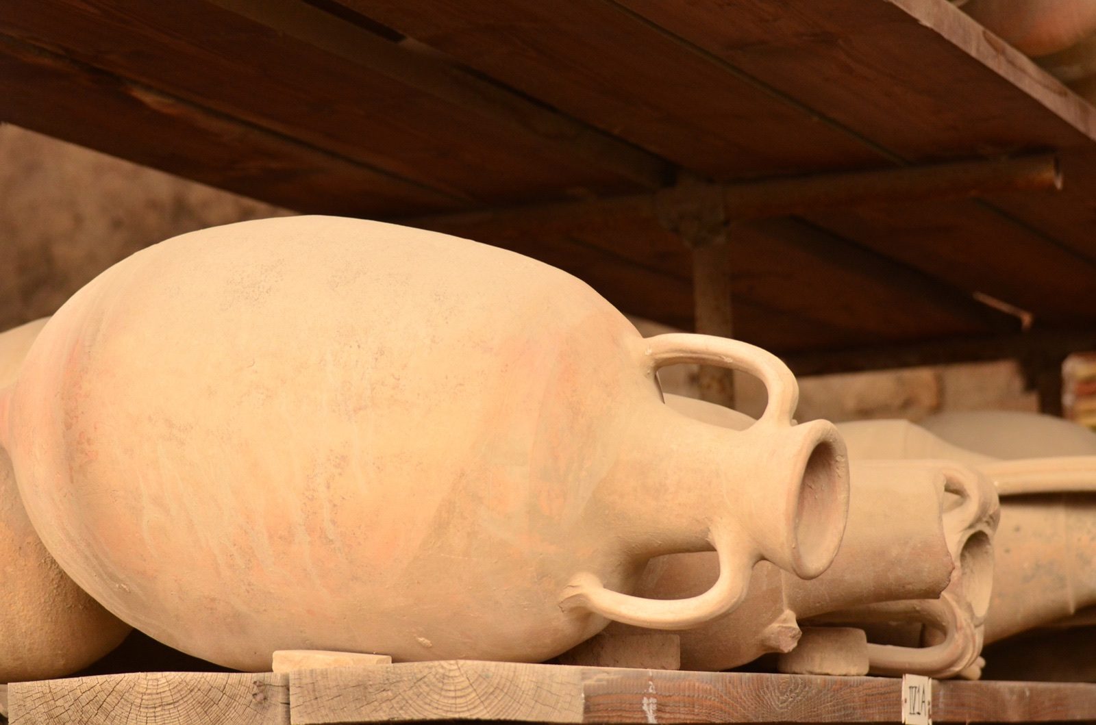 Rows of ancient clay storage jars in the ruins of Pompeii