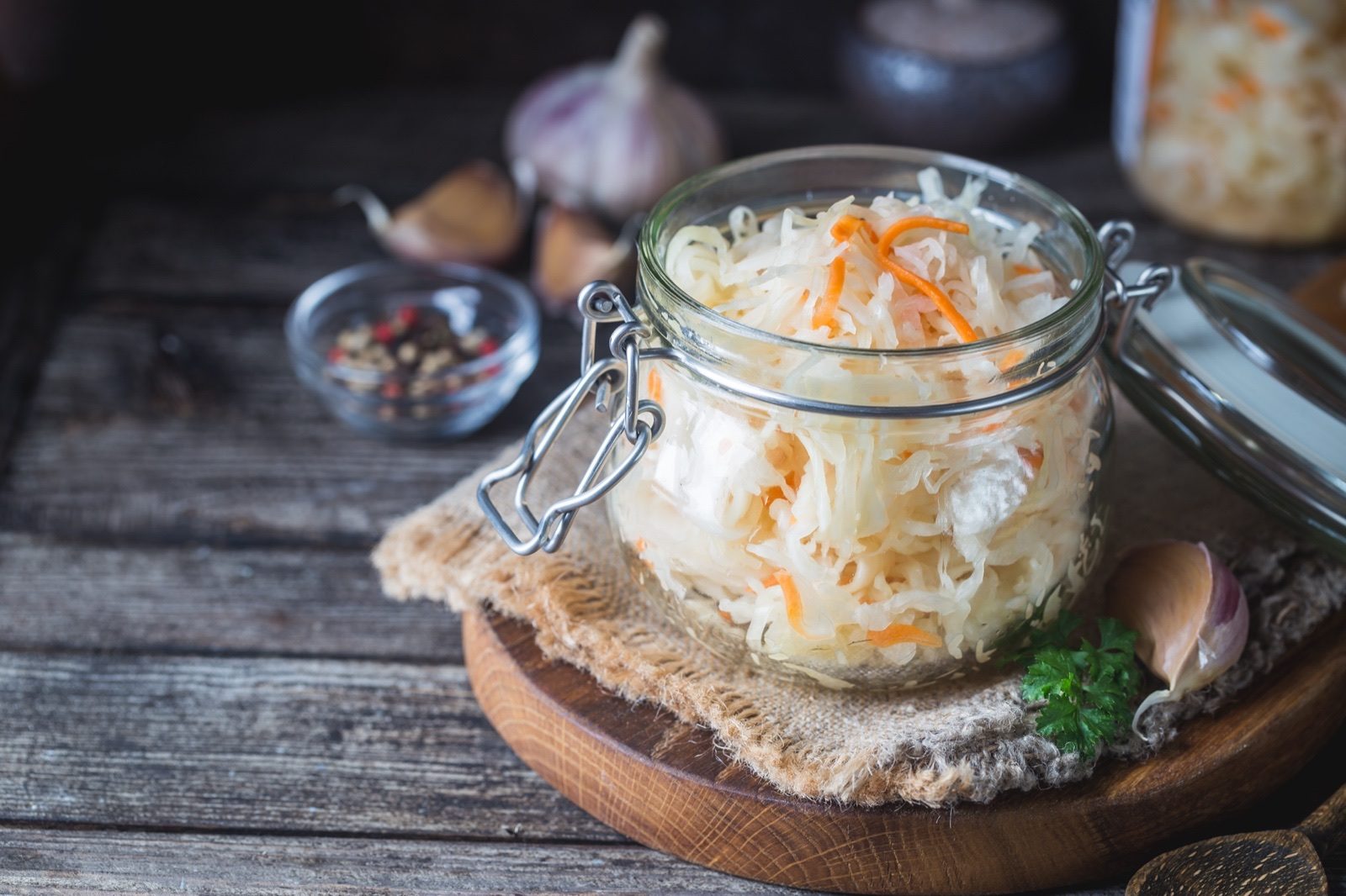 A glass jar of fermented sauerkraut on a kitchen counter