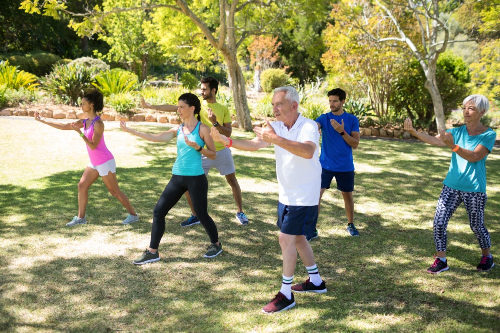 A group of older adults running together in a park on a sunny morning