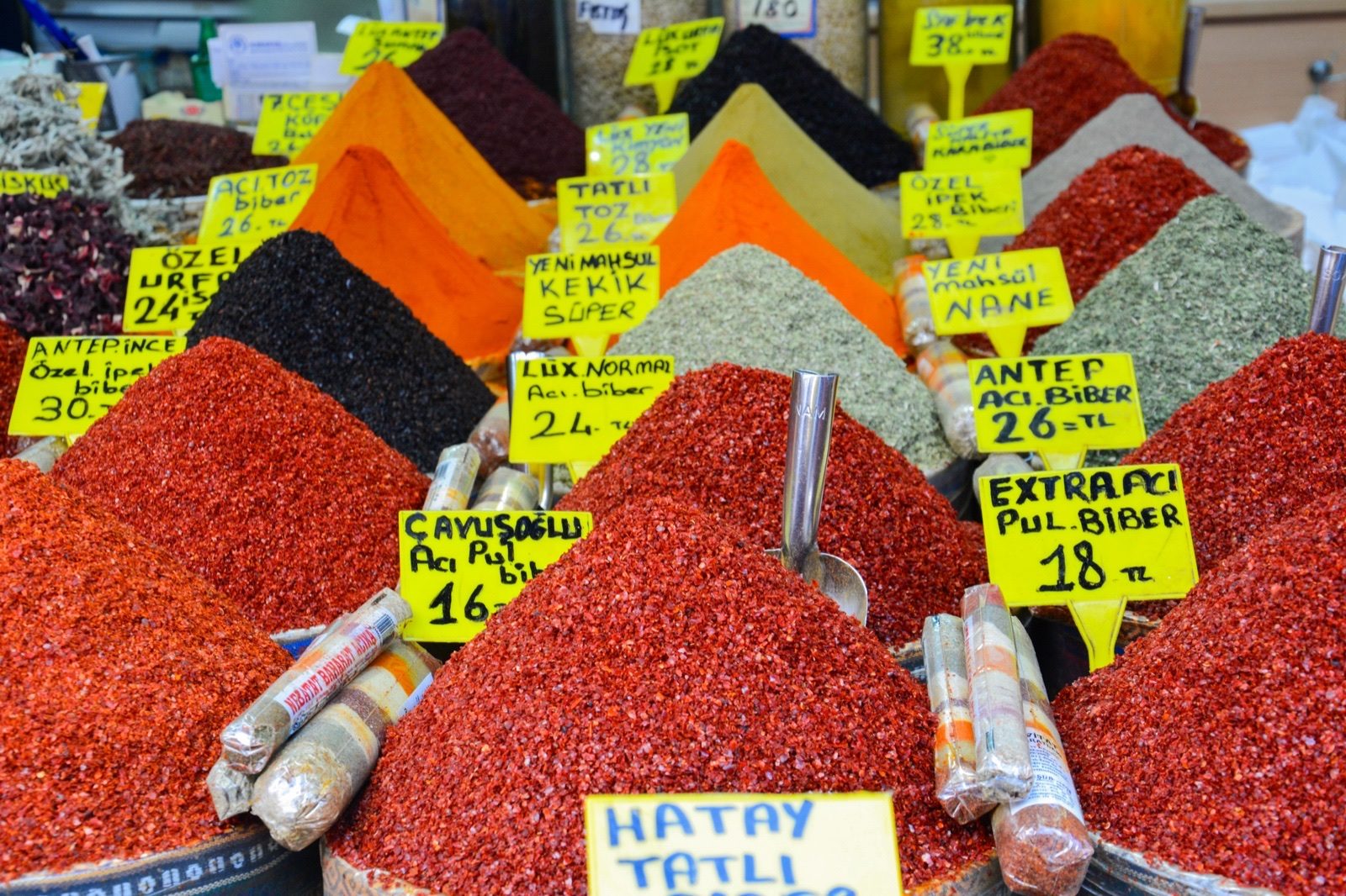 Sacks and trays of spices on display in a covered market